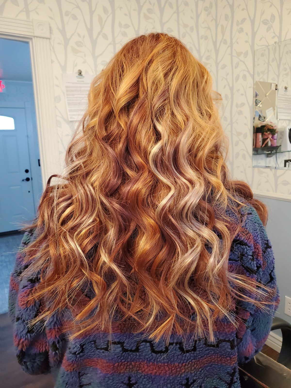 Long copper and strawberry-blonde waves with lighter money-piece highlights, shown from behind.