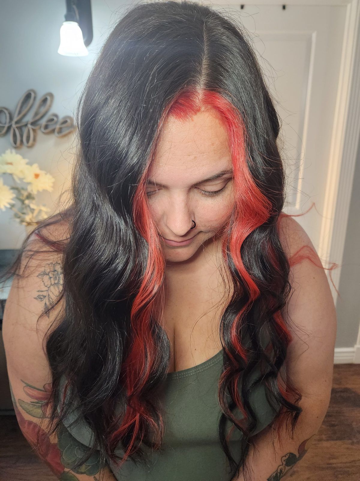 Long dark hair with a vivid red money-piece framing the face and red peekaboo panels, front view.