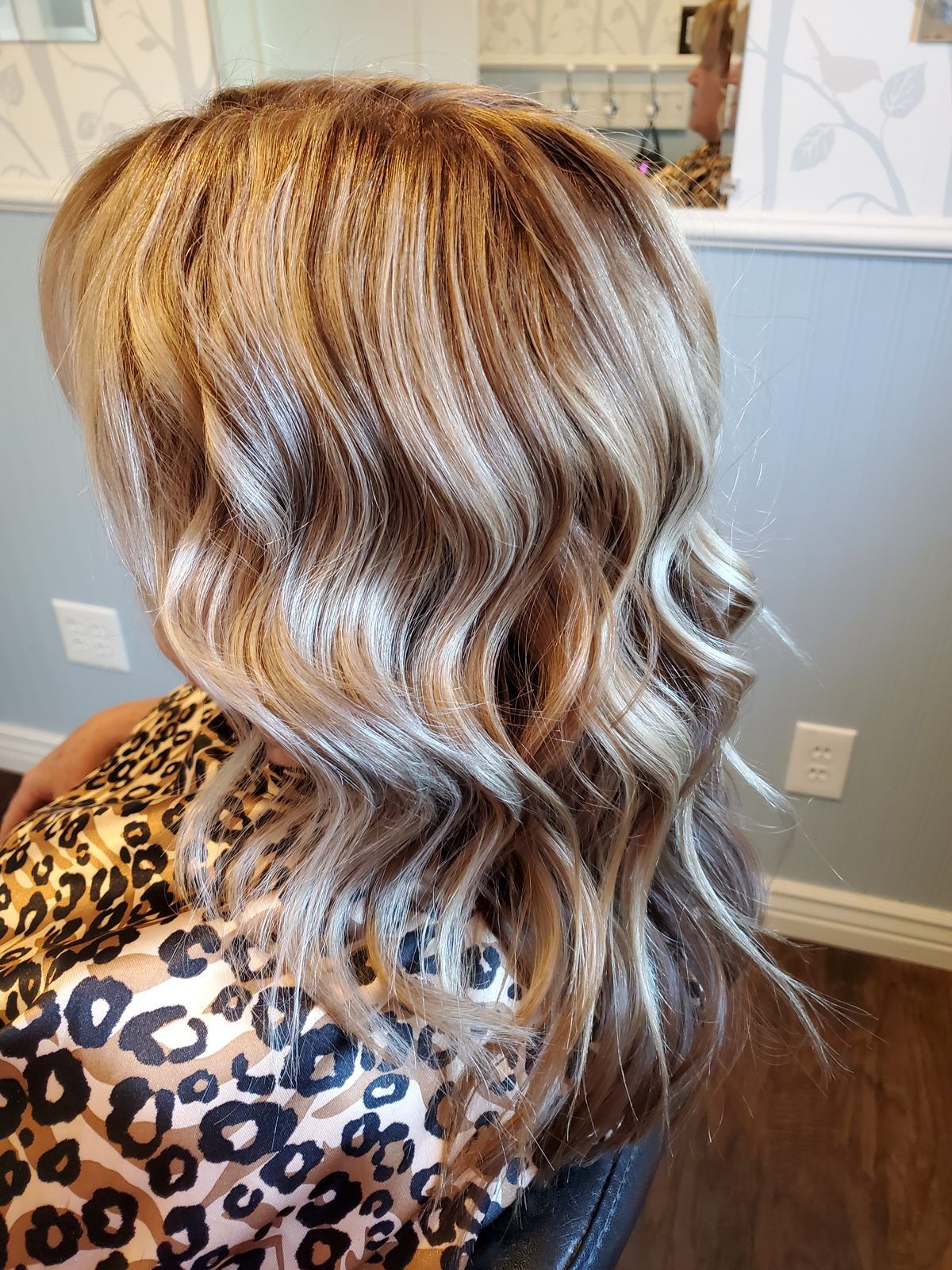 Shoulder-length hair with warm roots melting into cool silvery-blonde waves, shown from the side.