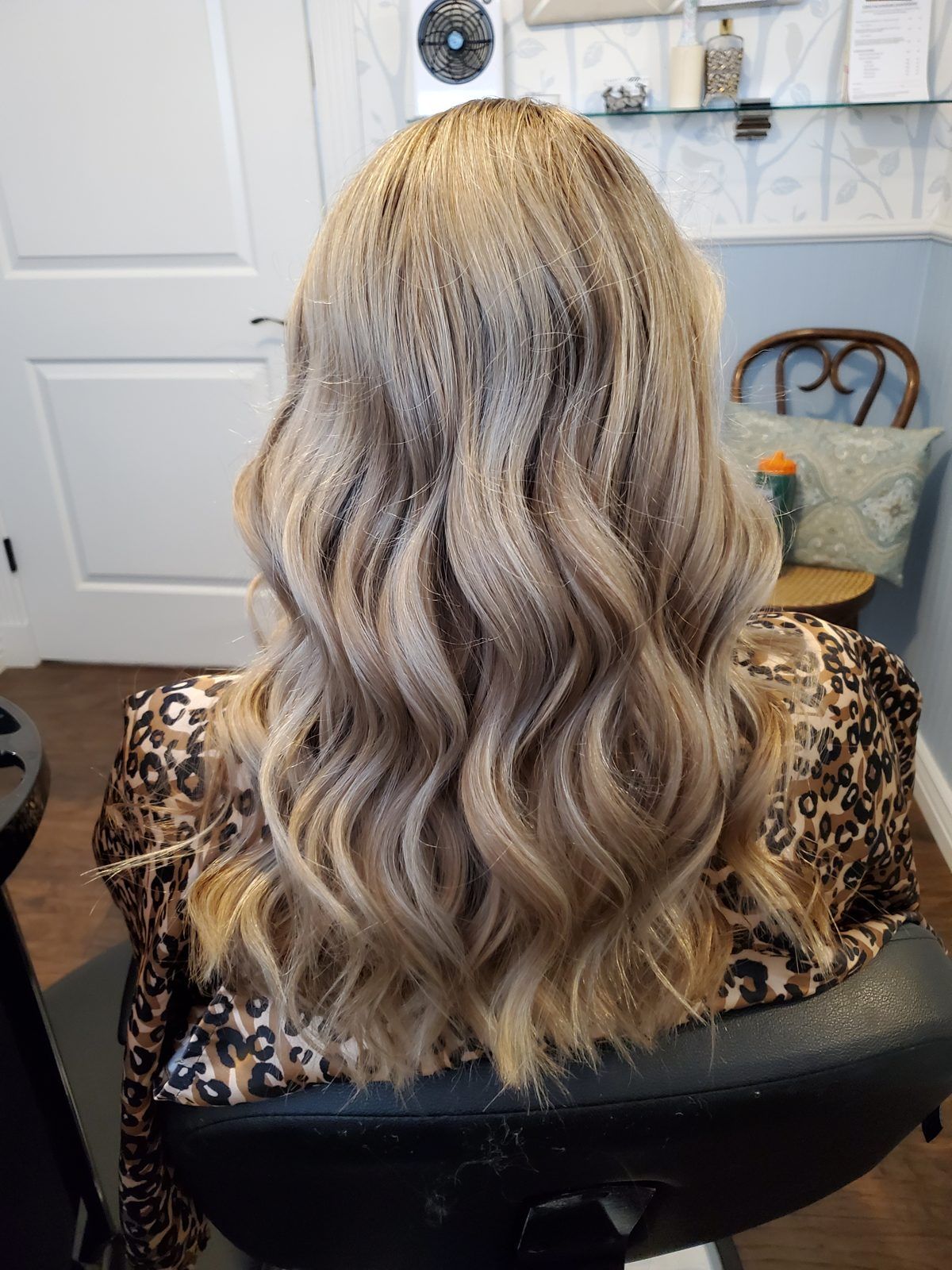 Shoulder-length ash-blonde waves, shown from behind.