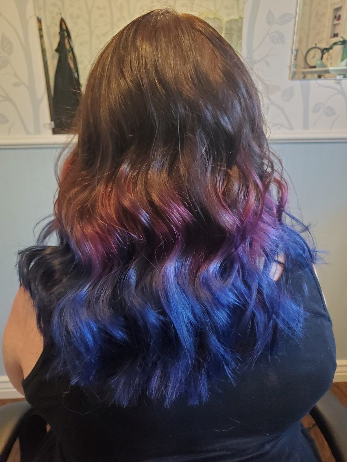 Dark brown hair melting into vivid purple and blue toward the ends, wavy, shown from behind.