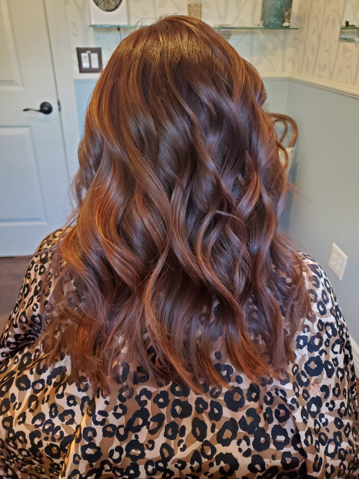 Rich auburn and copper-brown dimensional waves, shown from behind.