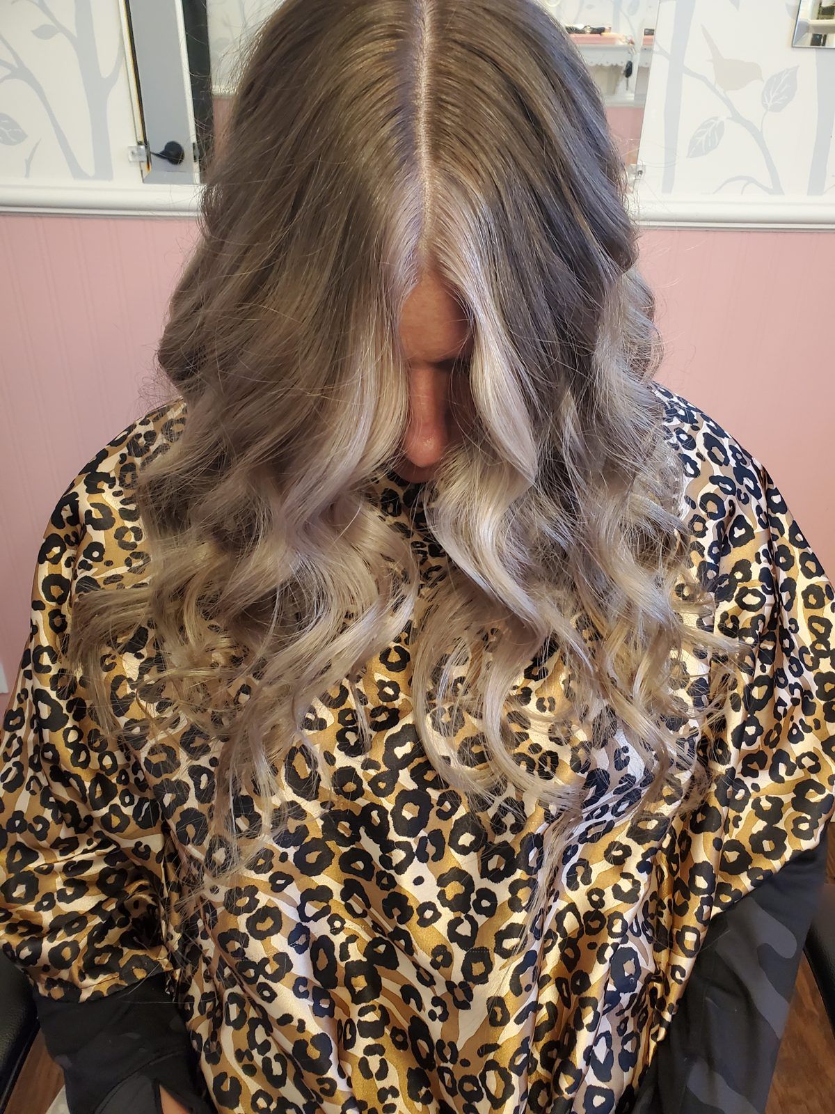 Cool ash-blonde waves with soft shadow roots, shown from above.