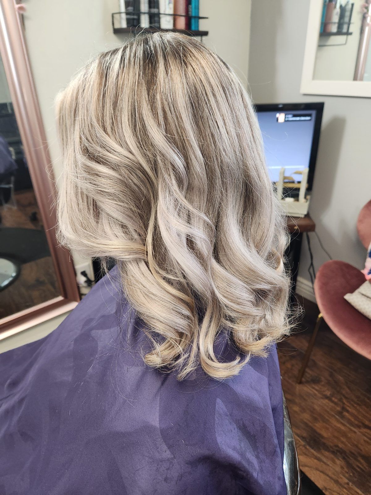 Dimensional ash-blonde waves at shoulder length, shown from the side.