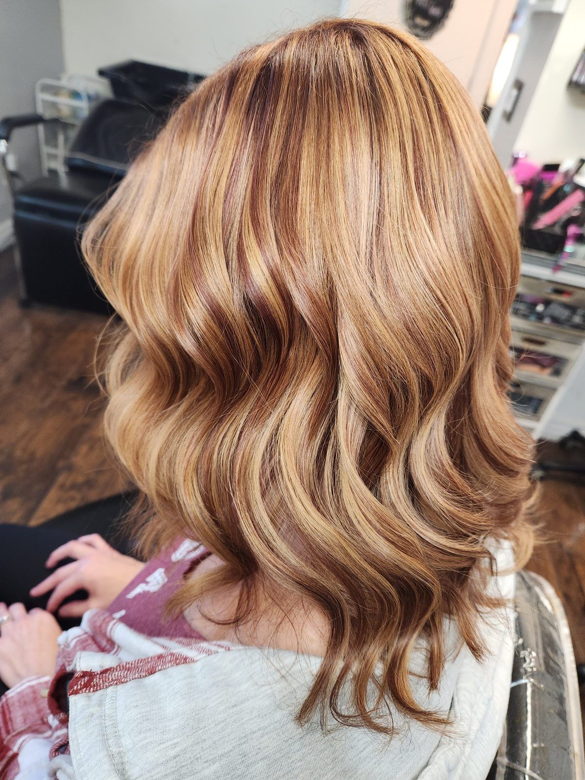 Copper and strawberry-blonde dimensional waves with ribbons of highlight and lowlight, side view.