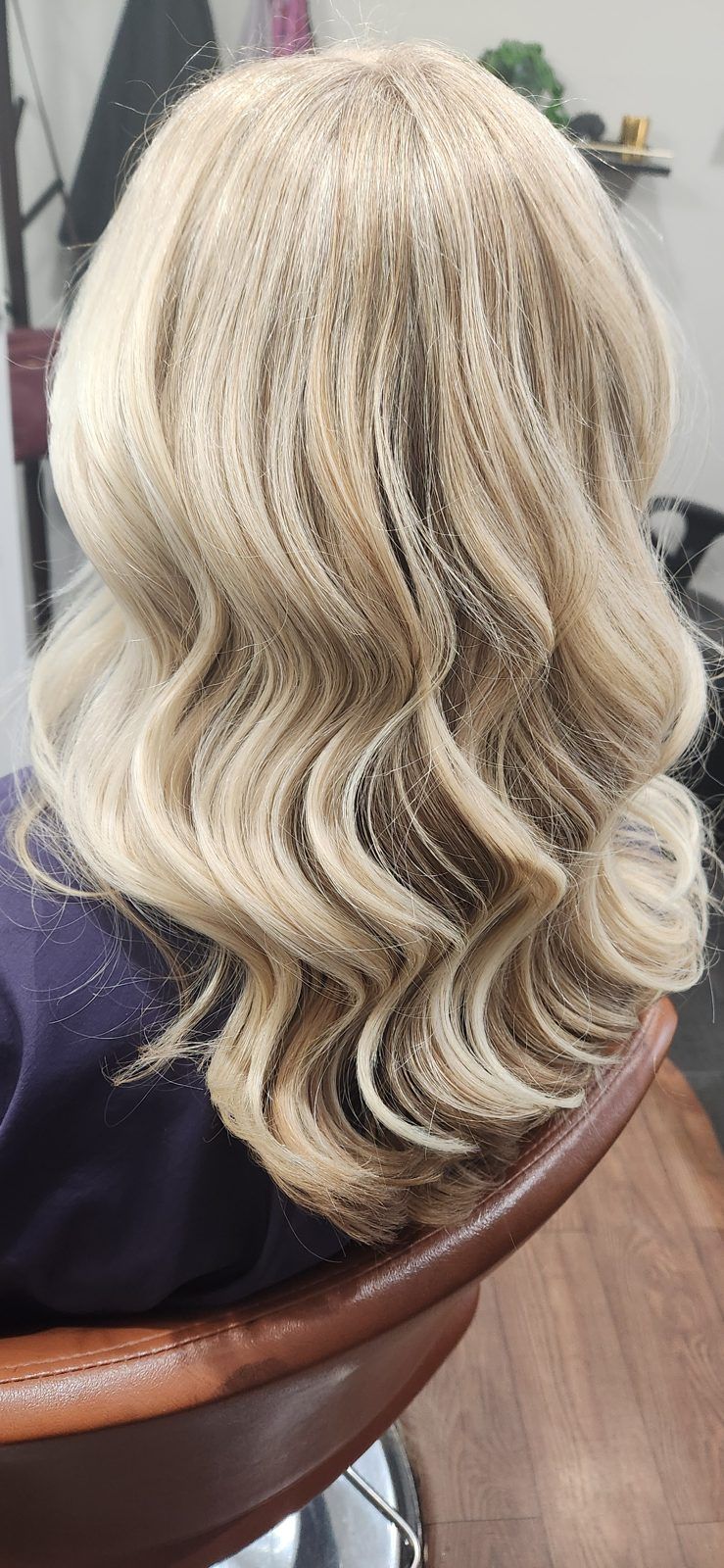 Cool blonde glamour waves with soft dimension, shown from the side.