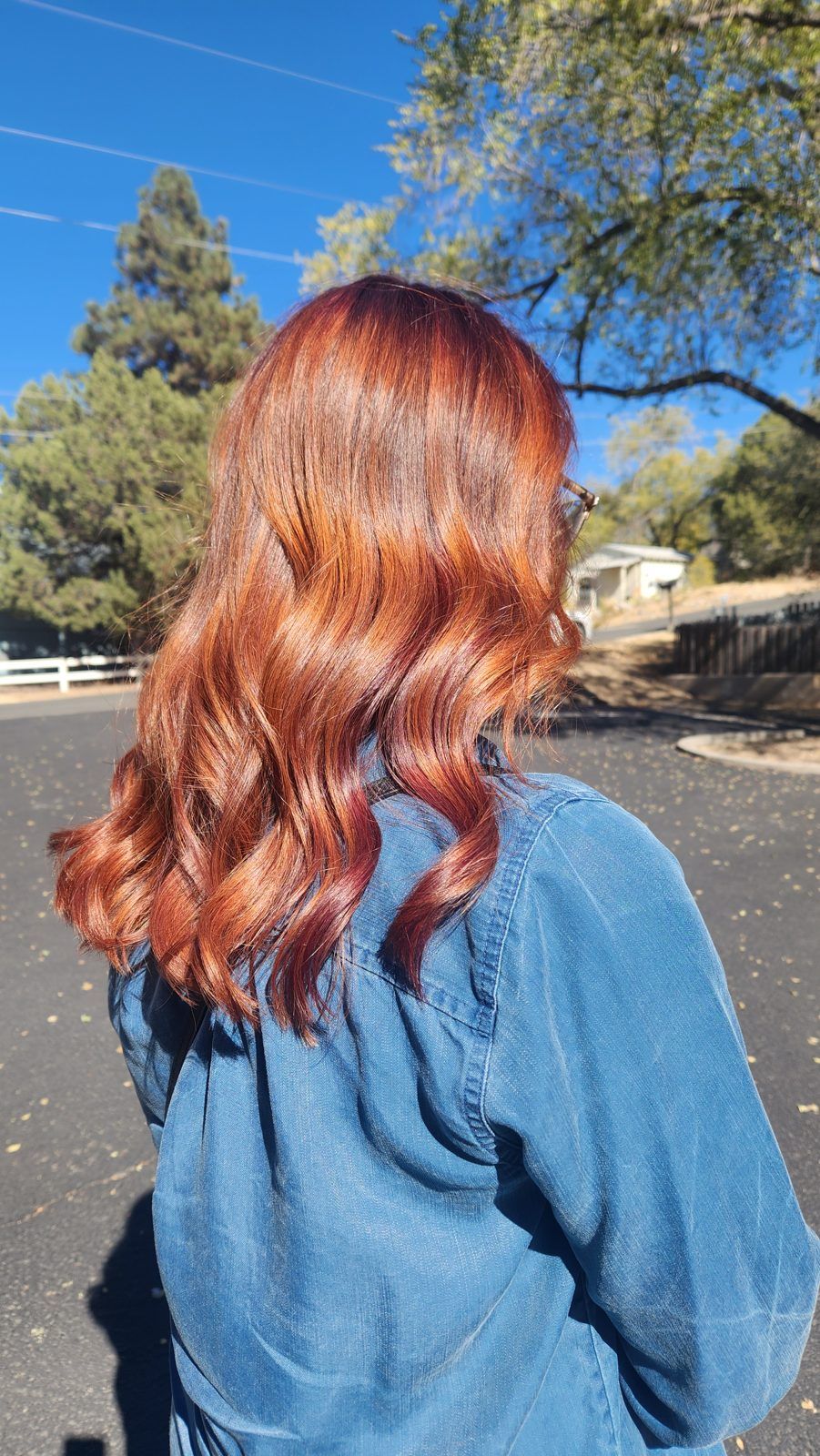 Vibrant copper-red waves with deeper red lowlights, shown from behind outdoors.