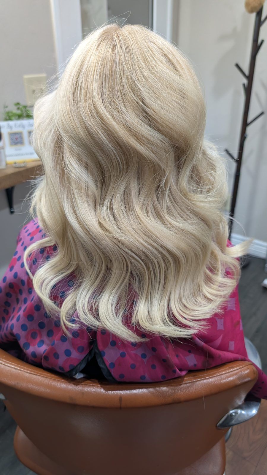 Bright buttery-blonde glam curls, shown from behind.